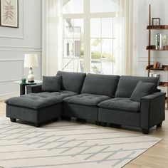 a living room with a gray couch and white rug