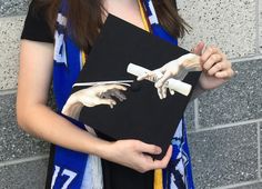 a woman holding a piece of art with hands on it