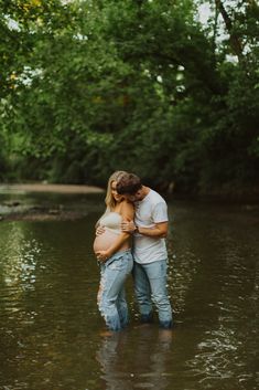 a pregnant couple hugging in the water