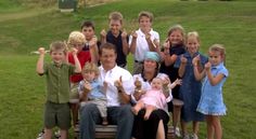 a group of people sitting on top of a bench giving the thumbs up sign in front of them