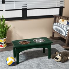 a green table with a dog bowl on it and a stuffed animal next to it