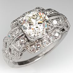 This captivating ring is centered with one (1) old European cut diamond weighing 1.63 carats and set into a four-prong setting. The ring features a pierced design and bordered with milgrain edging. The ring measures 11.4mm at the top, rises 5.8mm above the finger, tapering to 1.4mm wide and 1.2mm thick at the base of the shank. This ring is currently a size 4.75. One of the tiny accent diamonds is chipped but it is noticeable. Mafia Princess, Cabin Door, Art Deco Diamond Ring Engagement, Antique Diamond Engagement Rings, Princess Jewelry, Art Deco Diamond Rings, Antique Diamond Rings, Engagement Rings Platinum, Antique Engagement