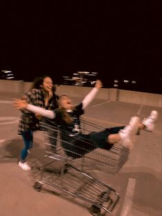 two women are sitting in a shopping cart