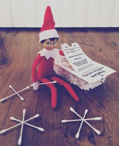 an elf is sitting on the floor next to some papers