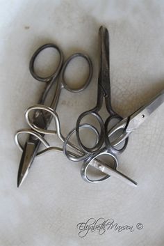 four pairs of scissors sitting on top of a white plate