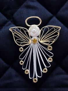 an angel ornament is shown on a black quilted surface with gold accents