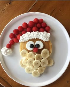 a white plate topped with pancakes covered in fruit and an image of a santa clause