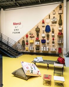 a room filled with lots of different types of bags on the wall and furniture in front of it