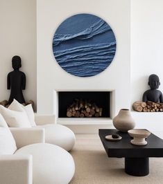 a living room filled with white furniture and a blue circular wall art above the fireplace