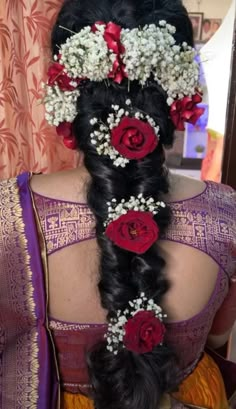 a woman with long hair and flowers in her hair is wearing a purple saree