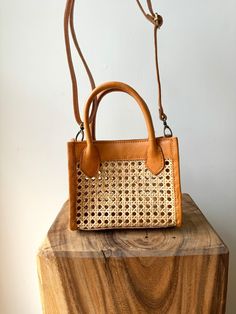 A small leather handbag with cane rattan detailing. The rectangle shape includes an optional strap to wear as a crossbody. Handmade by artisans in Indonesia. Each piece is unique, so slight variations may occur in the color, size and shape. Cane Accessories, Rattan Handbags, Classy Earrings, Rattan Bag, Black Rectangle, Jewelry Bags, Rectangle Shape, Leather Handbag, Sales Gifts