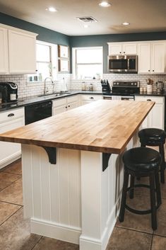 a kitchen island with two stools next to it