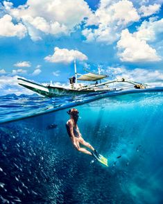 a man swimming in the ocean next to a boat