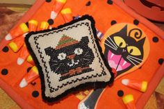 an orange tray with a black cat on it and candy in front of the plate