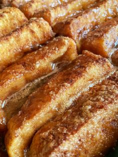 several pieces of french toast sitting on top of a green plate covered in powdered sugar