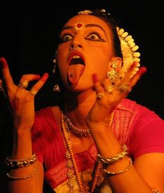 a woman with her hands in the air while wearing jewelry and making an obscene gesture