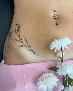 a close up of a woman's stomach with flowers on the side and behind her