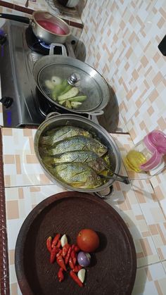 there are many different types of food on the counter top, including fish and vegetables