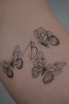 three butterflies with the letter b on each side of their back shoulder and upper arm