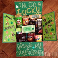 an open st patrick's day gift box filled with candy and snacks on the floor