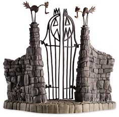 an iron gate with two birds on it and another bird sitting on top of the gate