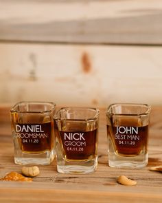 three shot glasses sitting on top of a wooden table