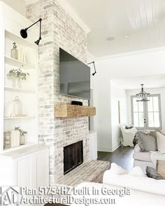 a living room with white furniture and a brick fireplace