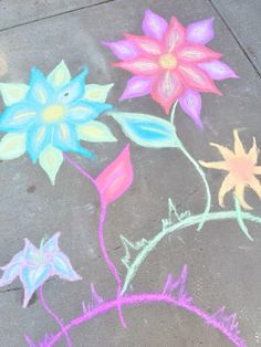 colorful flowers are drawn on the sidewalk with chalk