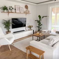 a living room filled with furniture and a flat screen tv mounted on a wall above a wooden coffee table