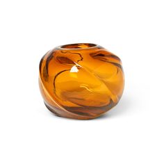 an orange glass vase sitting on top of a white table