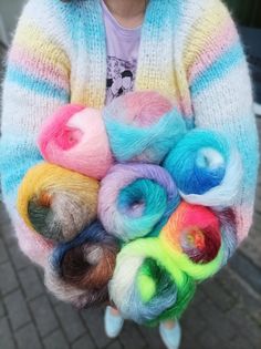 a person holding a bunch of colorful yarn