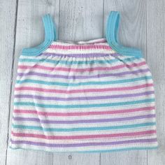 Cute striped tank top in purple, white, blue and pink. Terry cloth type material. Stripes have raised texture feel. Blue straps. Elastic at neckline. Pull over. Size: 9 months Measurements (approximate): Shoulder to Hem: 9.5" Armpit to Armpit: 8" Brand: Carrot Top Condition: Spot on front stripe, see pictures for details. Be sure to check out my shop! New items added often! https://www.etsy.com/shop/AutumnRoseArtVintage Striped Tank Top Vest, Striped Sleeveless Vest Top, Striped Tank Top With Vest Detail, Cute Blue Sleeveless Tank Top, Summer Striped Cotton Vest, Striped Cotton Sleeveless Tank Top, Striped Sleeveless Cotton Top, Cute Cotton Sleeveless Camisole, Purple Cotton Sleeveless Vest