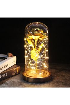 a lamp that is sitting on top of a table next to some books and a laptop