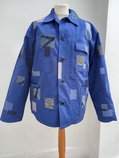 a blue jacket with patches on it sitting on a mannequin