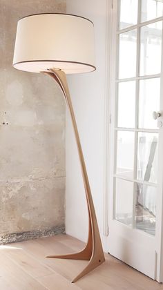 a lamp that is on top of a wooden floor next to a door and window