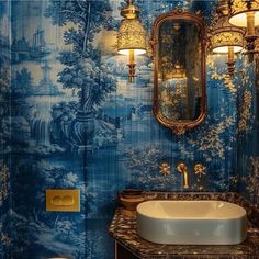 a bathroom with blue wallpaper and gold fixtures