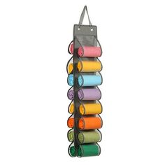 the yoga mat holder holds six rolls of colorful yoga mats, and is hanging on a wall