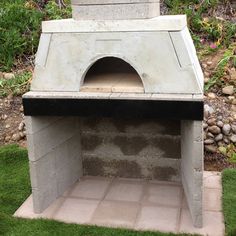 an outdoor pizza oven sitting in the grass