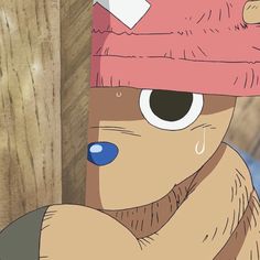 a cartoon bear wearing a pink hat with eyes and nose piercings, leaning against a wooden fence