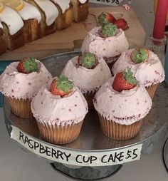 some cupcakes with strawberries on top are sitting on a silver platter