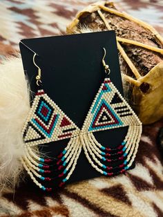 These beautiful handmade beaded hoop earrings are special , not only hand made by indigenous hands , but it's also made with colors that symbolize a heavy meaning . We call these "middle of somewhere "  , why so ? for the voyager who sets upon a destination not to think he or she is lost , but know they are always somewhere and they are always a someone . you  matter .  The color turquoise is associated with meanings of refreshing, feminine, calming, sophisticated, energy, wisdom, serenity, wholeness, creativity, emotional balance, good luck, spiritual grounding, friendship, love, joy, tranquility, patience, intuition, and loyalty.  The color maroon stands for passion and intensity , sophistication... wisdom and last but not least ... compassion .  The color of cream sits as a form of puri Southwestern Beaded Fringe Earrings As Gift, Southwestern Fringe Beaded Earrings As Gift, Southwestern Fringe Beaded Earrings For Gift, Southwestern Style Beaded Fringe Earrings For Gift, Artisan Jewelry With Beaded Fringe For Crafting, Unique Fringed Beaded Earrings For Festivals, Artisan Jewelry With Beaded Fringe, Unique Fringe Beaded Earrings For Festivals, Festival Beaded Earrings With Fringe