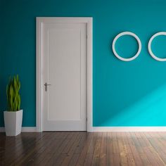 an open door in a blue room with two round mirrors on the wall and a potted plant next to it