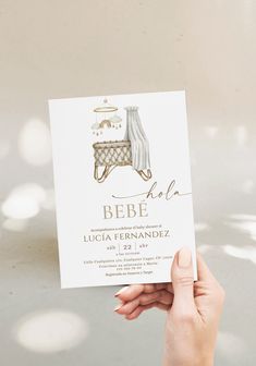 a person holding up a card with the word bebe in gold foil on it