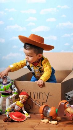 a young boy in a toy box with toys around him and his name on it