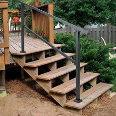 a set of wooden steps leading up to a deck with metal railing and handrails