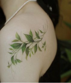 the back of a woman's shoulder with green leaves on it