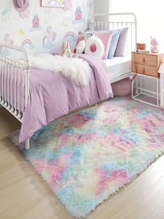 a child's bedroom with pastel colors and unicorns on the wallpaper