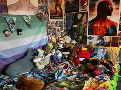 there are many stuffed animals on the bed in this room with posters all over the walls