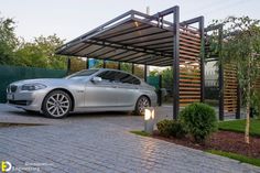 a silver car parked under a metal structure