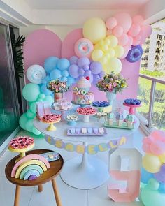 a table topped with lots of balloons and desserts